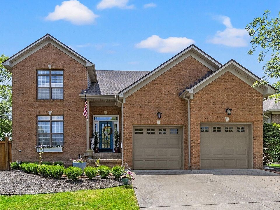 front of this beautiful home! two car garage, a wide driveway, a walkway to the home, and beautiful landscape